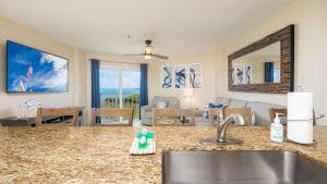 a kitchen with a sink and a living room at Coastal Joy 3412 Ocean Pointe in Tavernier