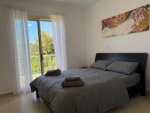 a bedroom with a bed with two towels on it at Elysia Park Star in Paphos +27 photos