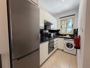 a kitchen with a refrigerator and a washing machine at Elysia Park Star in Paphos