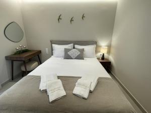 a bedroom with a large white bed with two pillows at Velithea Luxury Suites in Ioannina