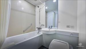 a white bathroom with a sink and a toilet at Daiwa Roynet Hotel Hachinohe in Hachinohe