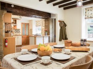 a kitchen with a table with a bowl of fruit on it at Hudson Cottage - Uk38152 in Newton