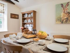 a dining room with a table with plates on it at Hudson Cottage - Uk38152 in Newton