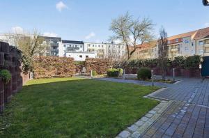 a courtyard with a lawn in front of some buildings at Central Suites in Greifswald +6 photos