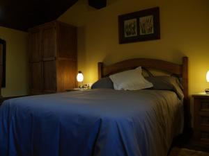 sypialnia z dużym łóżkiem i niebieskim kocem w obiekcie La casa del Vado w mieście Hervás