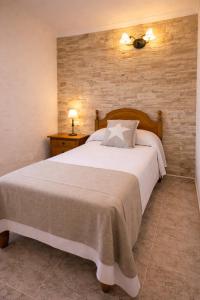 a bedroom with a large bed and a brick wall at Hotel Lago Dorado in La Savina