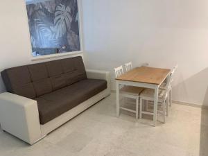 a couch and a table and a table and chair at Suite 55 in Trani