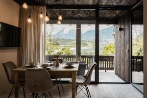 ein Esszimmer mit Tisch und Stühlen und einem großen Fenster in der Unterkunft Bäcksteinerhof in Meran