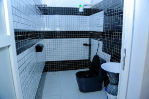a black and white bathroom with a toilet and a sink at Vegas Chillout Suites in Kampala