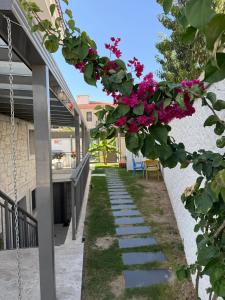 a pathway with pink flowers on a building at Olea Alacati in Çeşme