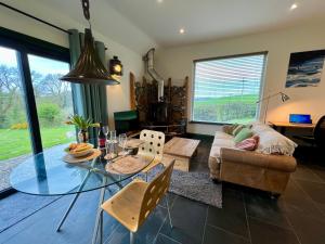 a living room with a glass table and a couch at Loom Cottage, Preseli Venture in Haverfordwest