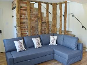 a blue couch with three pillows on it at The Old Stables in Bakewell