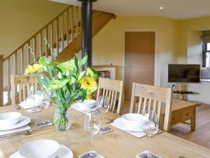 a dining room table with a vase of flowers on it at The Haymakers in Grange