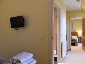 a room with a tv on a wall with towels at The Haymakers in Grange
