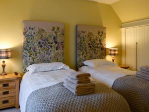 two beds in a room with towels on the bed at The Haymakers in Grange