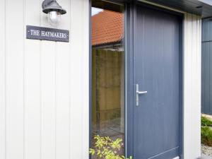 a blue door of a house with a sign on it at The Haymakers in Grange +20 photos
