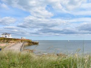 a view of a beach with a house and the ocean at Hyem in Amble
