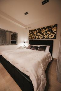 a bedroom with a large bed with a large headboard at Artemide Resort, Suite Spa Elysia in Lido Di Fondi +5 photos