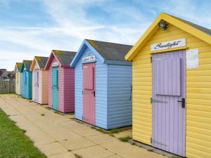 a row of colourful beach huts on a sidewalk at Hyem in Amble