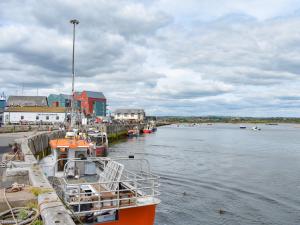 an orange boat is docked at a dock on the water at Hyem in Amble
