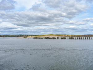 a large body of water with a pier in the distance at Hyem in Amble +14 photos
