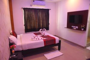 a room with a bed in a room with a tv at Hotel RD in Perundurai