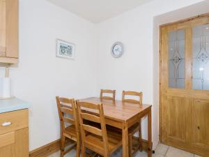 a dining room with a wooden table and chairs at Lazy Cottage in Haverigg