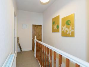 a staircase in a home with three paintings on the wall at Lazy Cottage in Haverigg +9 photos
