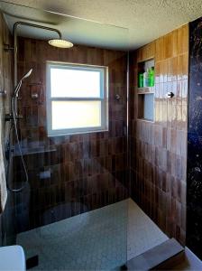 a bathroom with a shower with a window and a glass door at Ambervine in Lowell +15 photos