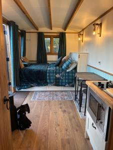 a small room with a bed and a table at The Apple Farm Glamping in Snitterfield