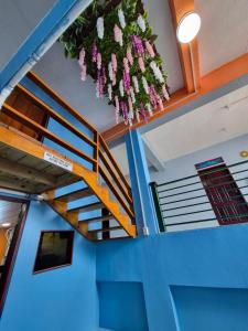 a room with a staircase with purple and white flowers at Caye Caulker Hostel in Belize City