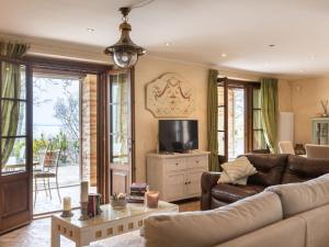 a living room with a couch and a tv at Villa Oleandra sul Lago by Interhome in San Feliciano