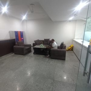 a man sitting on a couch in a room at Palam residency pg in Gurgaon