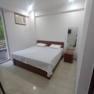 a bedroom with a bed in a white room at Palam residency pg in Gurgaon