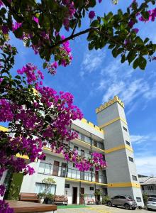 a building with purple flowers in front of it at Pousada Castelo do Rei in Penha