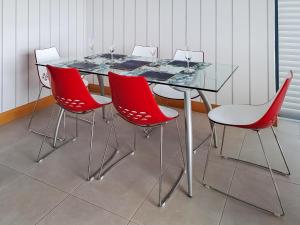 a glass table with four red chairs around it at Park Barn in Whittington