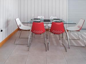 a dining room with a table and four red chairs at Park Barn in Whittington