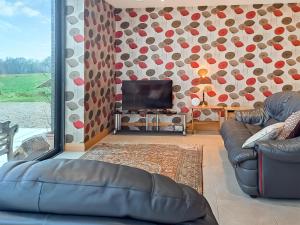 a living room with two couches and a tv at Park Barn in Whittington