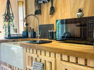 a kitchen counter with a microwave and a sink at Otter Gulley in Eddleston