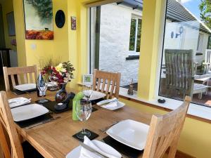 a wooden table with chairs and a dining room at Teenys Cottage in Flashader