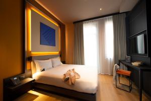 a hotel room with a bed and a television at Palazzo Loreto Hotel Milano in Milan
