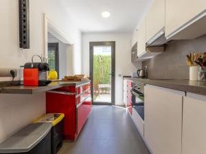 a kitchen with red and white cabinets at Holiday Home La Barca by Interhome in Cambrils