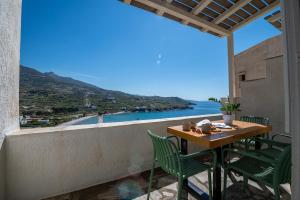 a table and chairs on a balcony with a view of the ocean at Kyma in Kardhianí