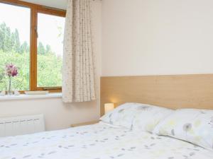 a bedroom with a white bed with a window at Sandhole Barn in Snodland