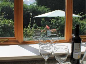 two wine glasses sitting next to a bottle of wine at Sandhole Barn in Snodland