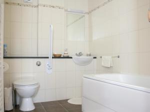 a white bathroom with a toilet and a sink at Sandhole Barn in Snodland +1 photo