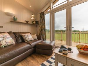 a living room with a brown leather couch and a table at Karelia Lodge in Kenmore