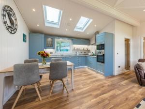 a kitchen with blue cabinets and a table and chairs at Karelia Lodge in Kenmore