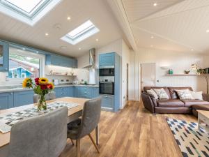 a kitchen and living room with blue cabinets and a table at Karelia Lodge in Kenmore