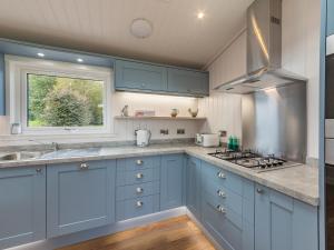 a kitchen with blue cabinets and a window at Karelia Lodge in Kenmore +7 photos